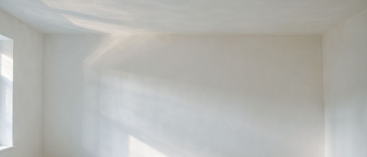 Freshly skim-coated smooth white ceiling meeting a clean wall line